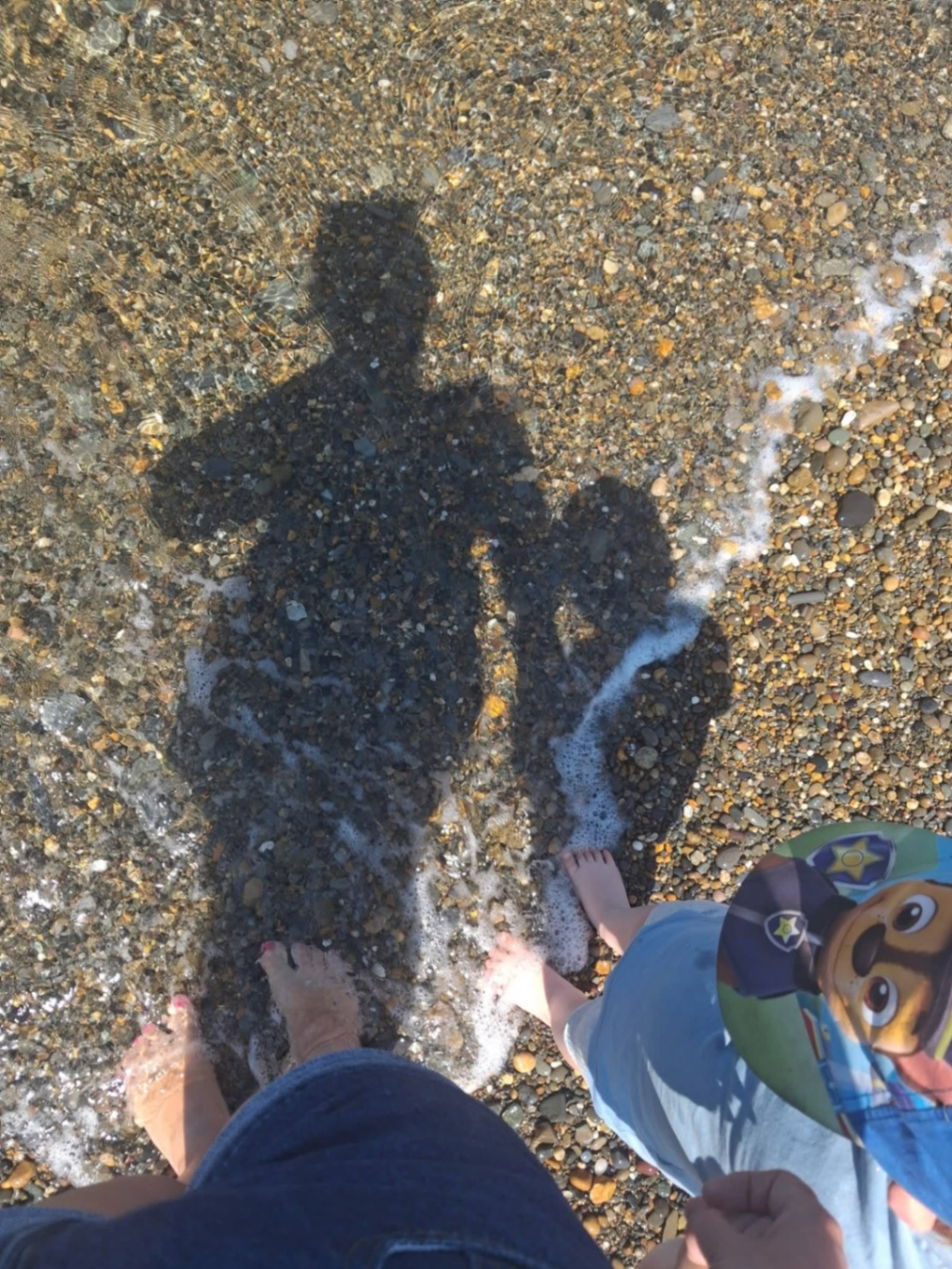 Paddling in the shallows with shadows on the pebbles