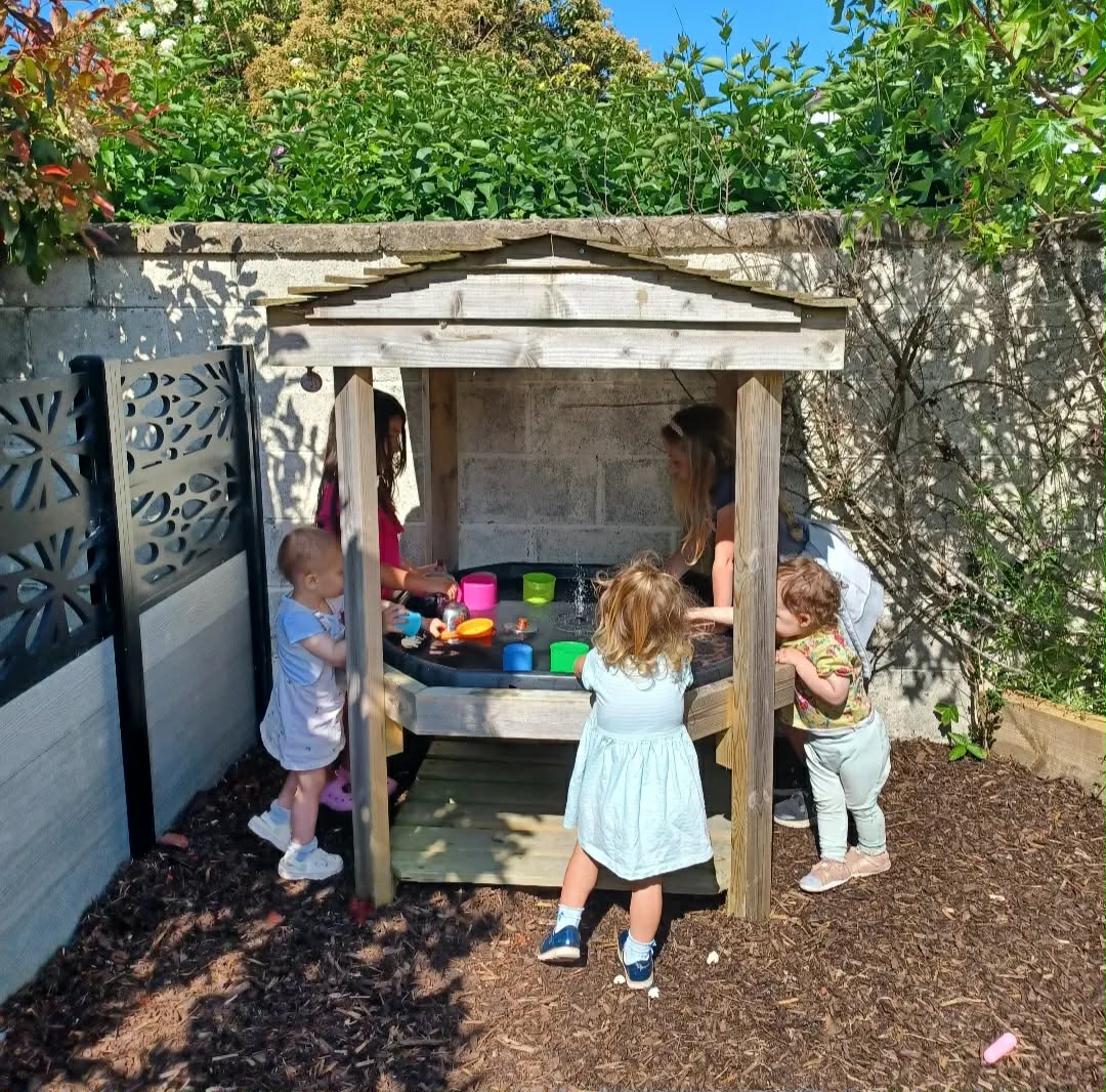 Children playing together at the outdoor mud kitchen