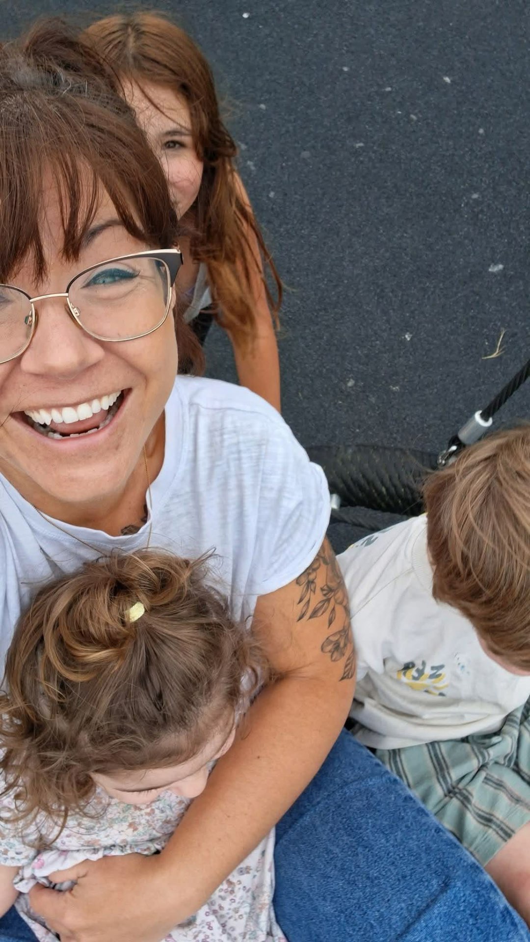 Laura laughing with the children on a swing