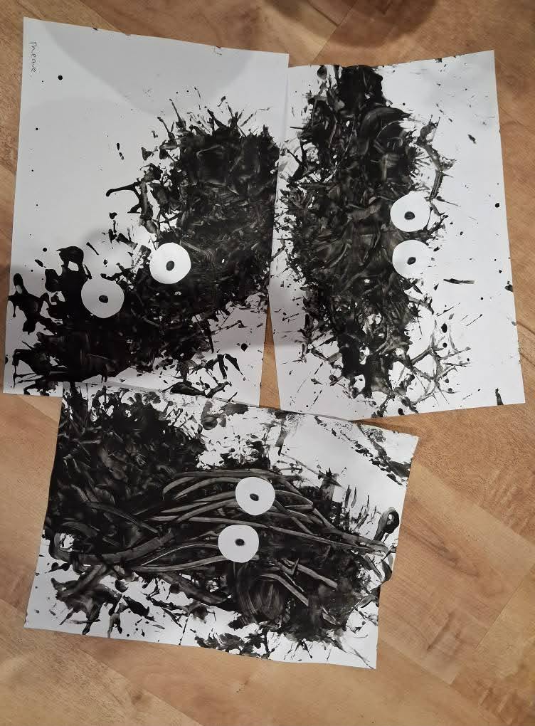 Black splatter-paint monster pictures made by the children